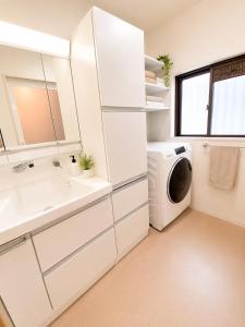 a bathroom with a sink and a washing machine at Hotel Airport Komatsu in Komatsu +58 photos