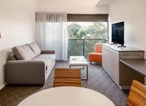 a living room with a couch and a tv at Mantra Hobart Airport in Hobart