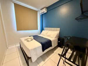 a small bedroom with a bed and a chair at Apto com 2 quartos e A/C no Centro in Montes Claros