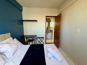 a bedroom with a bed with two towels on it at Apto com 2 quartos e A/C no Centro in Montes Claros