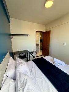 a bedroom with a bed and a table in it at Apto com 2 quartos e A/C no Centro in Montes Claros +42 photos