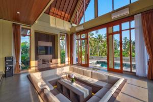 a living room with a large couch and a tv at Nandikara Villa in Payangan
