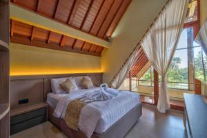 a bedroom with a bed and a large window at Nandikara Villa in Payangan +66 photos