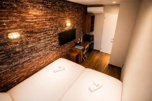 a living room with a brick wall and a couch at KAJAhause in Osaka +33 photos