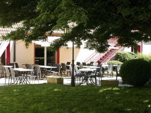 a group of tables and chairs in front of a building at Mercure Hexagone Luxeuil in Luxeuil-les-Bains
