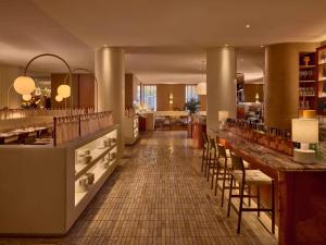 a restaurant with a bar and some tables and chairs at Sofitel Sydney Wentworth in Sydney