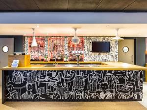 a bar with a wall covered in graffiti at ibis Leeds Centre Marlborough Street in Leeds