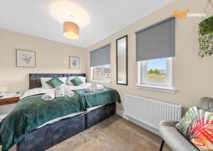 a bedroom with a bed and a chair and windows at 2Br House I Sleeps 4 I Cumbernauld in Cumbernauld