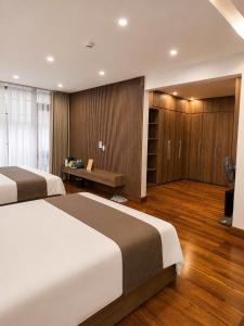 a bedroom with two beds and a bench in it at Mỹ Hương Hotel in Quang Tri