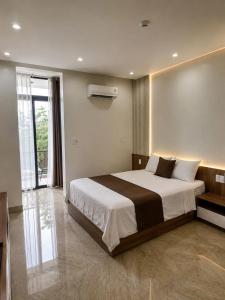 a bedroom with a large bed and a window at Mỹ Hương Hotel in Quang Tri