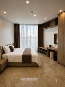 a bedroom with a large bed and a large window at Mỹ Hương Hotel in Quang Tri