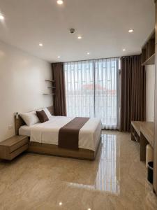 a bedroom with a large bed and a large window at Mỹ Hương Hotel in Quang Tri