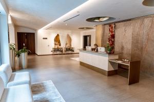 a lobby with a woman sitting at a reception desk at Grand Duka Hotel & SPA in Durrës
