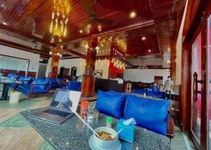 a restaurant with a table with a laptop on it at Mongkol Angkor Residence in Phumĭ Trăm Néak