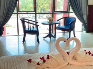 two swans made out of towels on a bed at Mongkol Angkor Residence in Phumĭ Trăm Néak