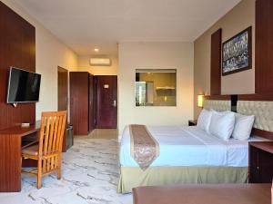 a hotel room with a bed and a desk at Spencer Green Hotel Batu in Punten