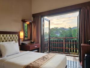 a hotel room with a bed and a large window at Spencer Green Hotel Batu in Punten