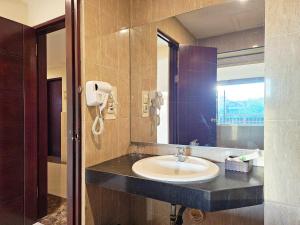 a bathroom with a sink and a mirror at Spencer Green Hotel Batu in Punten