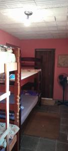 a room with two bunk beds and a door at Recanto da Serra e camping in Itamonte