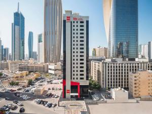 a tall white building in a city with cars at ibis Sharq in Kuwait