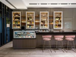 a bar in a restaurant with pink stools at Novotel Trabzon in Trabzon
