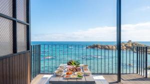 a table with food on a balcony with a view of the ocean at Yeongdeok Searest Poolvilla in Yŏngdŏk
