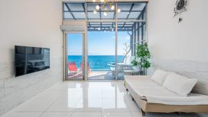 a living room with a couch and a tv and the ocean at Yeongdeok Searest Poolvilla in Yŏngdŏk +2 photos