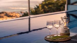 two wine glasses and a lantern on a table at Yeongdeok Searest Poolvilla in Yŏngdŏk