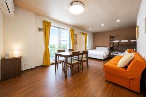 a living room with a couch and a table and a bed at ミニョン マッペ in Osaka