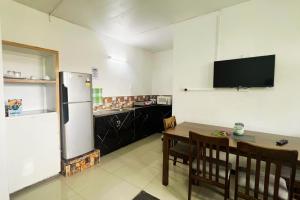 a kitchen with a refrigerator and a table with chairs at Townhouse Apartment Hotel Suva in Suva