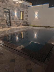 a swimming pool in a house with a stone wall at Villa zahra 7 in Kêf Bisnês +27 photos