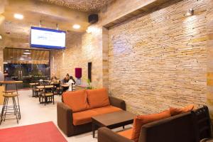 a lobby with chairs and tables and a brick wall at Hotel Tibet International in Kathmandu
