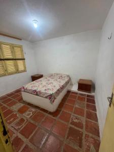 a bedroom with a bed in the corner of a room at Casa de Praia do Morro Branco in Beberibe