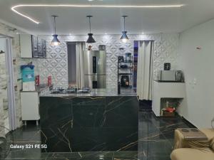 a kitchen with a large black counter top at Barrinha Beach flats in Saquarema +13 photos
