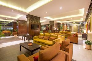 a living room with yellow couches and a television at Hotel Tibet International in Kathmandu +17 photos