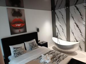 a bedroom with a large bed with a bath tub at HERA Elysium Apartament EROS in Sinaia