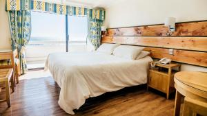 a bedroom with a large bed and a window at Hotel Nilahue in Viña del Mar +11 photos