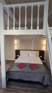a loft bed with two red pillows on it at Apartment in Zentrum Skandi in Vinnytsya