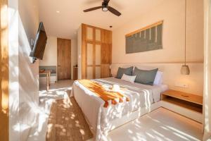 a bedroom with a bed with a ceiling fan at Amazing 1BR Tulum Jungle with Restaurant, Pool and Gym in Tulum +40 photos
