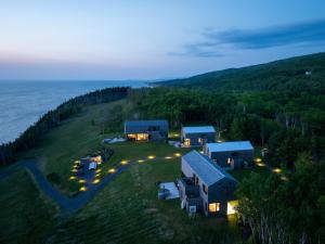 an aerial view of a house on a hill next to the ocean at Ridge On The Chimney - 4 Cottages in Chimney Corner