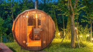a wooden sauna in the grass next to a tree at Sokcho Biroso Private Cottage in Sokcho