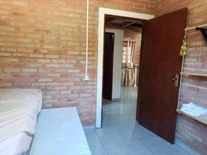 a room with a brick wall and a door at Chalé Mandala de Pedra in São Thomé das Letras