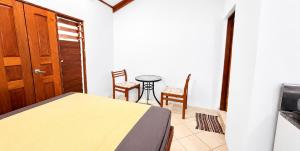 a bedroom with a bed and a table and chairs at Bluepango Guest House in Port Vila