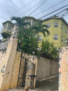 a building with a gate with a palm tree on it at The Cozy Haven Bed and Breakfast in Montego Bay
