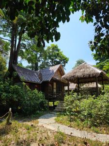 a small house with a thatch roof and a porch at Jansom Bungalow 2 in Ko Phayam