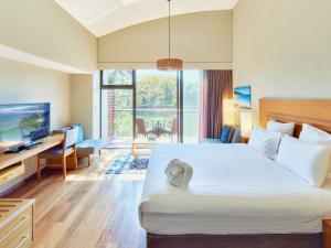 a hotel room with a large bed and a television at Pullman Bunker Bay Resort Margaret River in Dunsborough