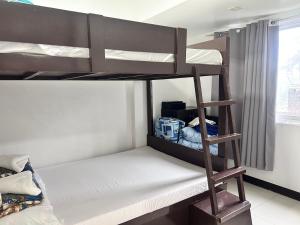 two bunk beds in a room with a window at 2BR Burnham Hill Condo for 8 -DOT Accredited in Baguio