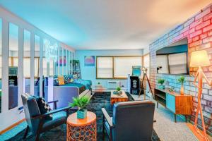 a living room with a bed and chairs in a room at 90s Condo| King Bed | 65” Smart TV | Arcade Game in Elmwood Park