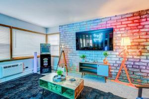 a living room with a brick wall at 90s Condo| King Bed | 65” Smart TV | Arcade Game in Elmwood Park +9 photos