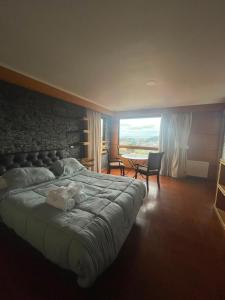 a bedroom with a large bed and a large window at Hotel Peregrino Suites in Concepción